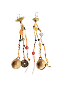 A pair of long dangling earrings with a mix of orange, yellow, and black beads, gold discs, and white pendants.