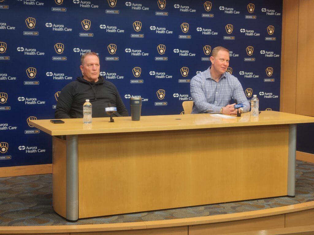 Brewers manager Pat Murphy and general manager Matt Arnold at a press conference podium at American Family Field in Milwaukee.