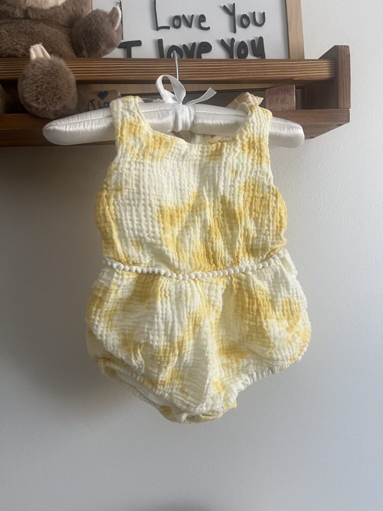 A photo of a yellow child's romper