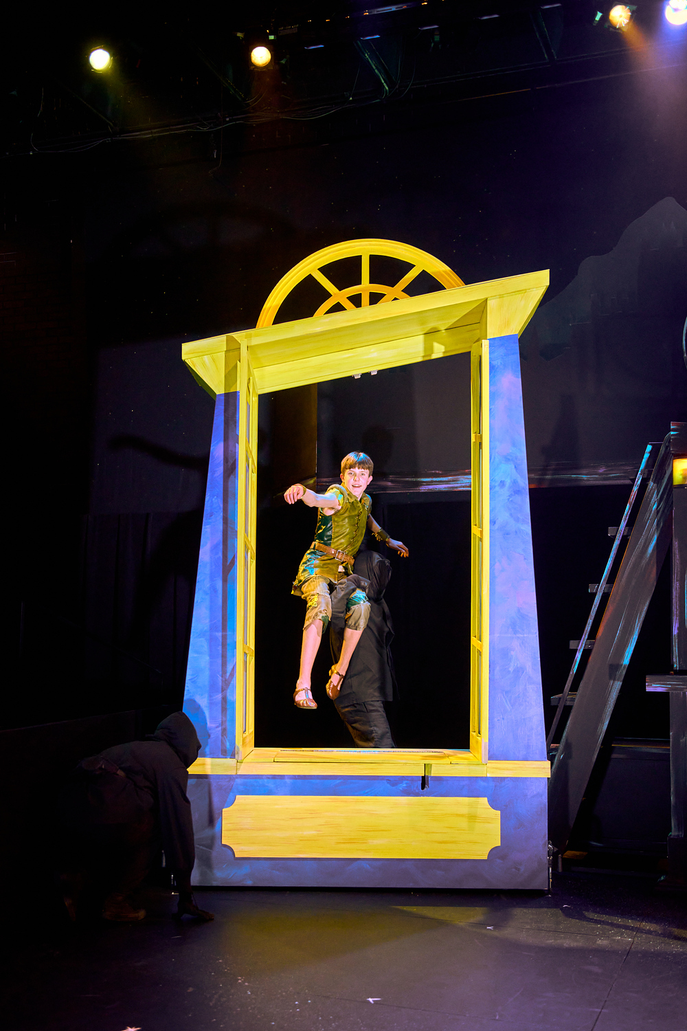 An actor playing Peter Pan jumping through a window during a First Stage production.