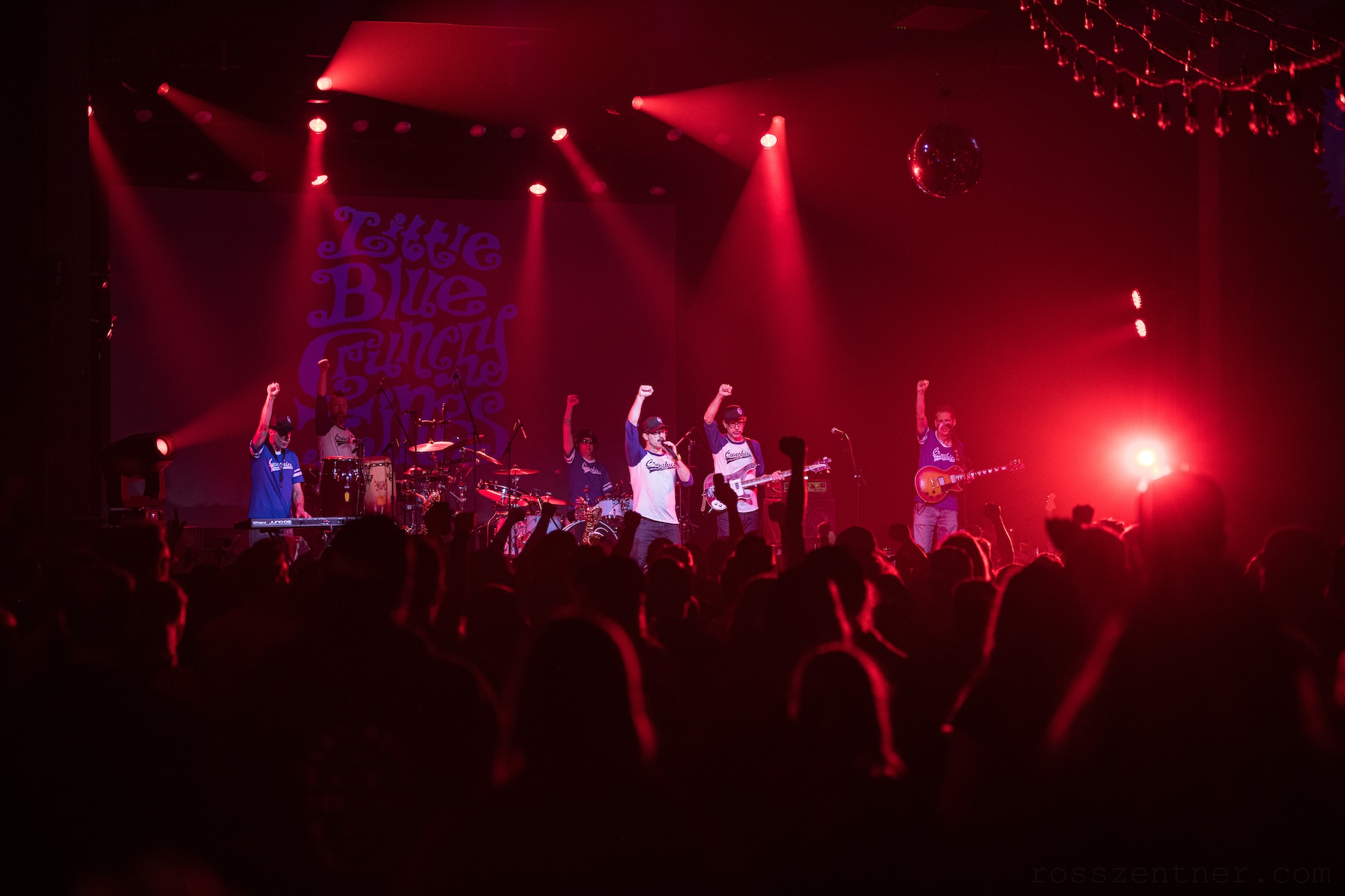 Members of Little Blue Crunchy Things raise their fists during a concert at Turner Hall Ballroom.