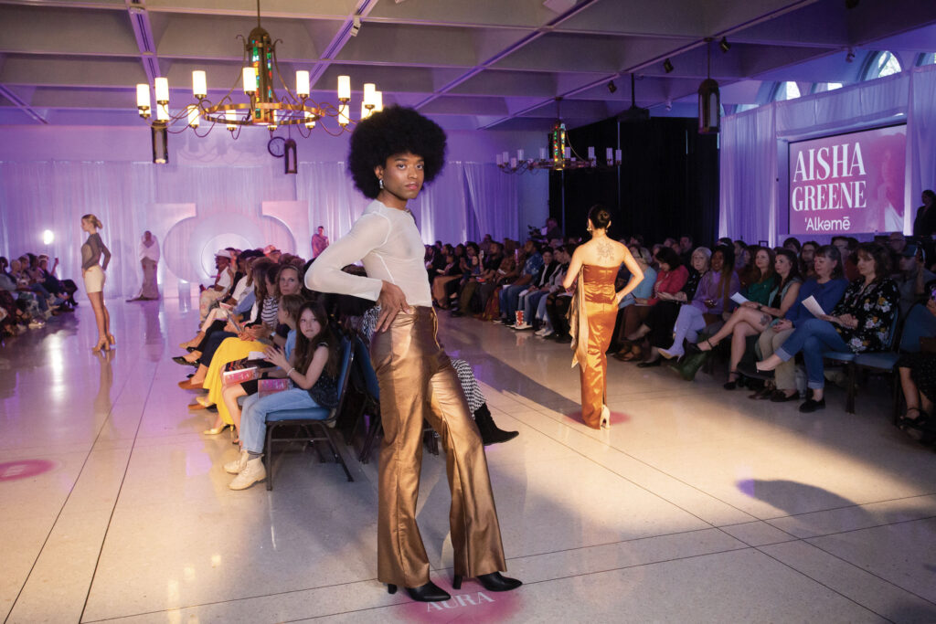 A model stops and strike a pose at the tip of the runway at the Mount Mary Student Fashion Show