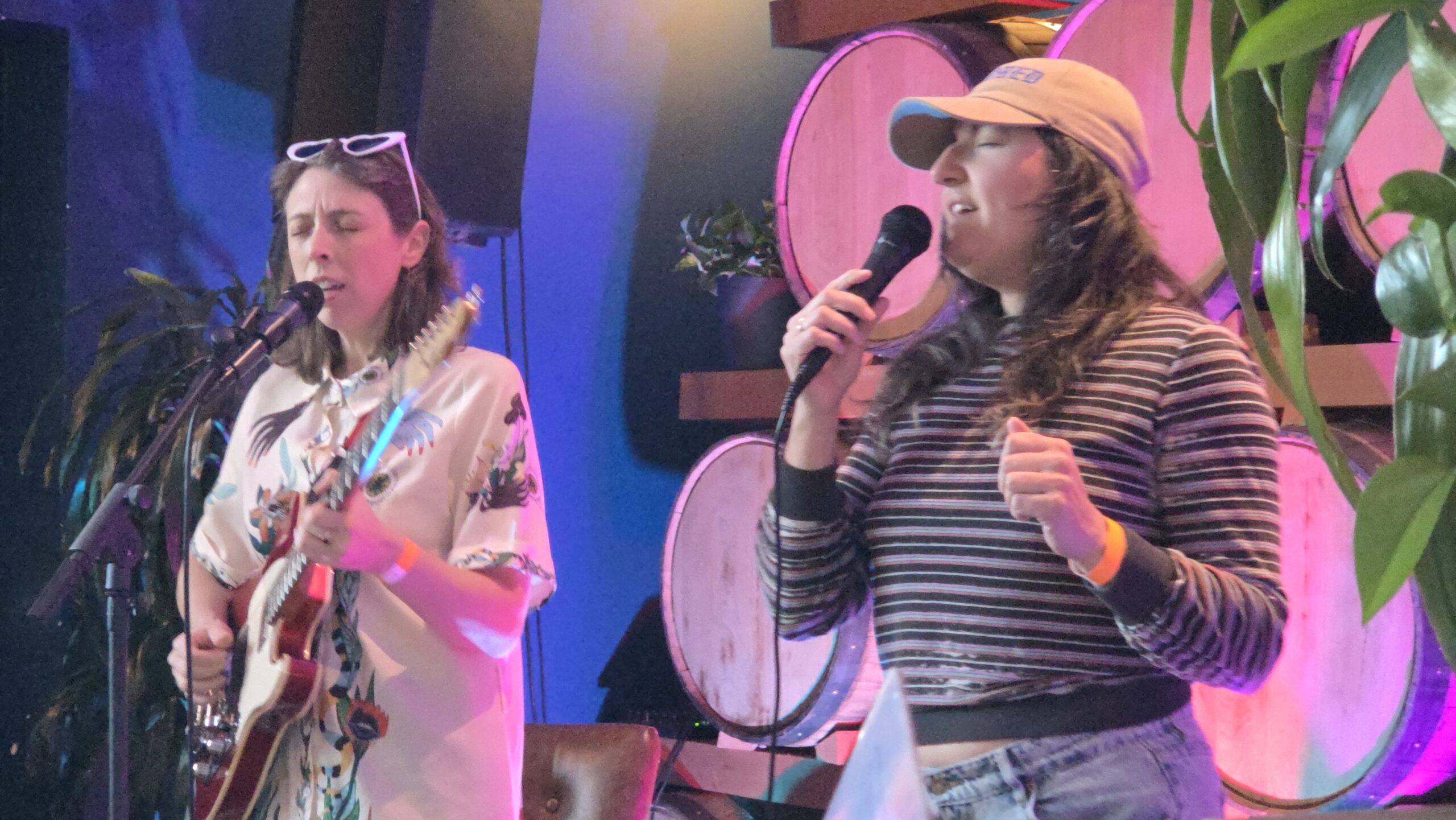Caley Conway, playing guitar, and Ellie Jackson sing together at Indeed Brewing in Milwaukee.