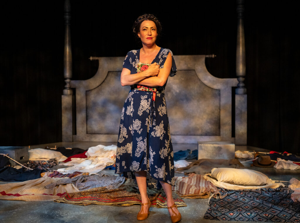 Vanessa Severo performing as Frida Kahlo, holding a book tight, in Milwaukee Rep's "Frida...A Self Portrait."