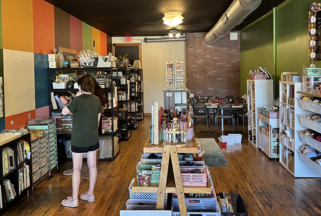 The inside of 414 Art Revival, with colorful walls and filled with boxes and shelves of gently used crafts.