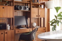 In the office, original walnut paneling adds an unmistakable richness, while the curtains, also original, invite softness and depth. The pendant light is original as well, pairing function with vintage charm. Photo by Kevin J. Miyazaki.