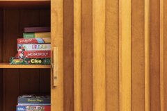 The closet's accordion doors are original to the home, and the interior holds family-favorite games, puzzles and books – all to be enjoyed in the nearby den. Photo by Kevin J. Miyazaki