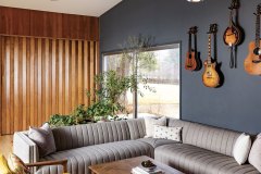 The den now functions as a favorite spot to unwind and features a pair of vintage teak chairs from Annie’s grandparents’ cottage. The guitars are a nod to Nick, a musician, and can be easily removed from the wall for spontaneous jam sessions. Photo by Kevin J. Miyazaki
